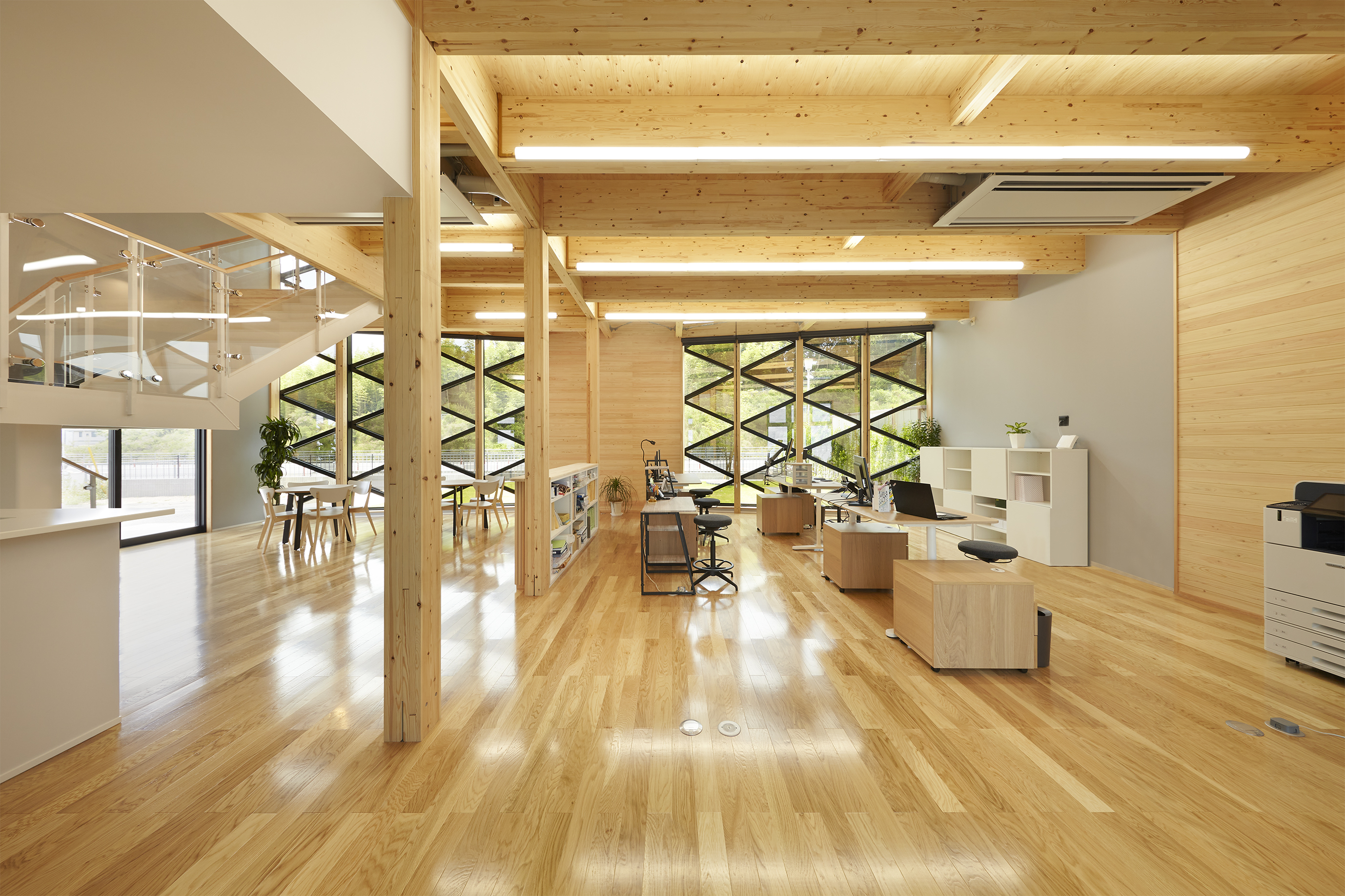 この木造の事務所には、地域に貢献する会社としてサスティナブルな事業展開をするためにさまざまな設計のアイデアが盛り込まれています。  外観の特徴的なガラスのファサードを通じて、開放的な木質空間の雰囲気が伝わる建築デザインとなっています。  ＜画像＞    ＜「くみあい運輸新社屋」の概要＞ ・用途：事務所 ・構造：木造（SE構法） ・階数：2階建て ・延床面積：186.90㎡  関連記事：SE構法の事務所の事例紹介「くみあい運輸新社屋」